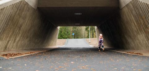 Pikkutyttö kävelee alikulkutunnelissa.