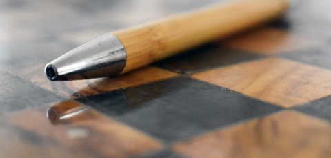 Puinen kynä sakkilaudalla.