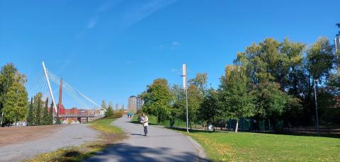 Sähköpotkilautailija kävely- ja pyörätiellä Ratinanniemessä, taustalla Laukonsilta.