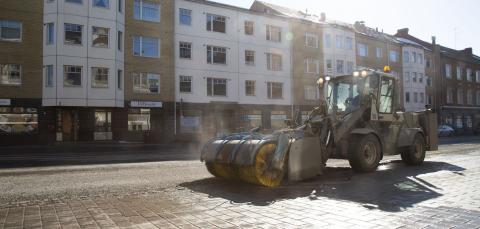 Harjaustraktori puhdistaa katua keväällä.