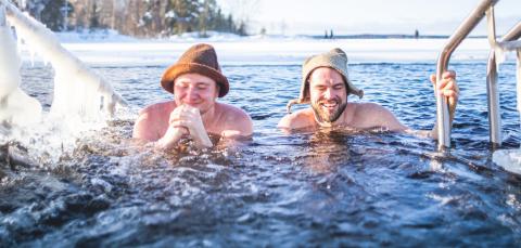 Two people ice-swimming in Rauhamiemi