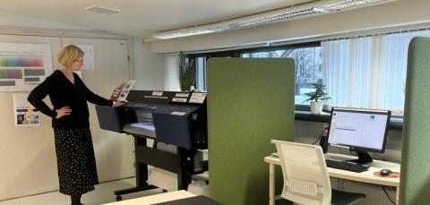 Henkilö harrastustila Visiossa suurkuvatulostimen vieressä.