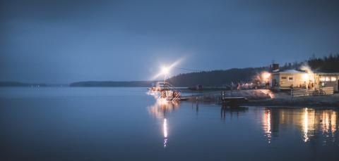 Rauhaniemen kansankylpylän valot loistavat Näsijärvestä syyshämärässä.