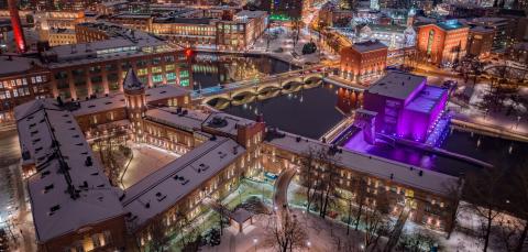 Dronekuva öisestä joulutorista osana kauniisti valaistua kaupunkia.