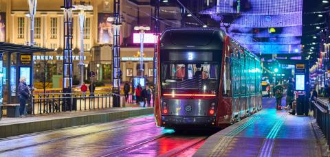 The purple light curtains on top of the tram in the night in Tampere.