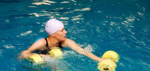 A woman is doing water aerobics.