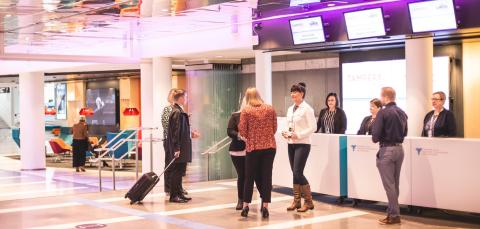 Ihmisiä rekisteröitymässä tapahtumaan tiskillä. 