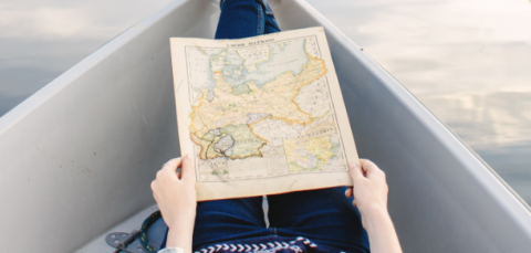 A woman is in the boat. She is holding a map.