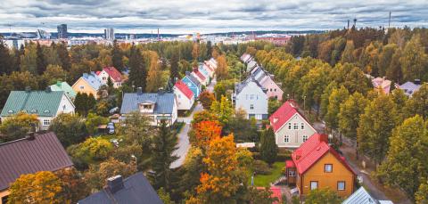 Petsamon värikkäitä puutaloja syksyisessä maisemassa.