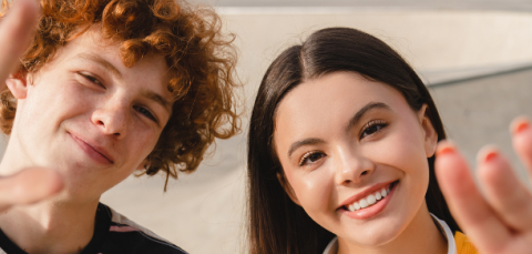 kaksi iloista nuorta katsomassa kameraan