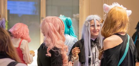 Nuoria cosplay-harrastajia monitoimitalolla. 