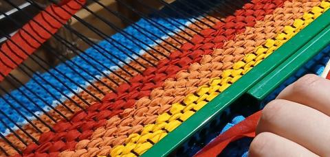 kuva kangaspuista ja värikkäästä langasta.