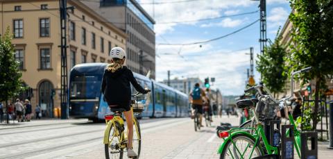 Pyöräilijöitä Hämeenkadulla, taustalla kulkee ratikka.