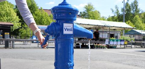 A woman's hand is turning on the drinking water faucet at Tammelantori.