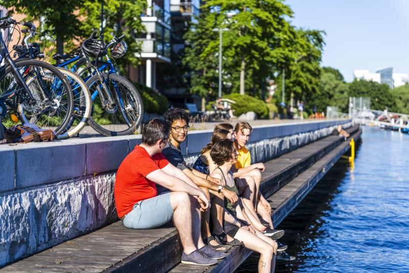A few people sitting on the pier in Ratina in summer.