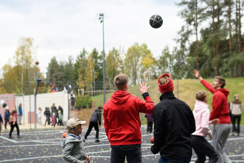 Young people are playing basketball outside.