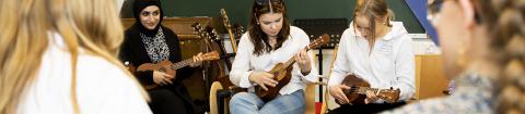 Lukiolaisia soittaa ukuleleja musiikintunnilla.