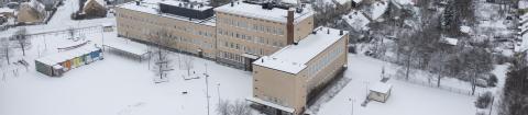 Nekalan vanha koulurakennus kuvattuna ilmasta talvisena päivänä.
