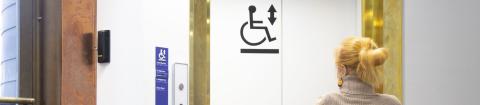 Pyörätuolia käyttävä henkilö odottaa hissiä.