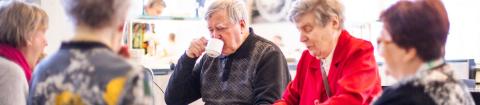 A group of elderly people having coffee.