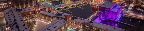 Dronekuva öisestä joulutorista osana kauniisti valaistua kaupunkia.