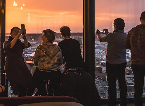 Ihmiset katsovat auringonlaskua Torni-hotellin ylimmästä kerroksesta