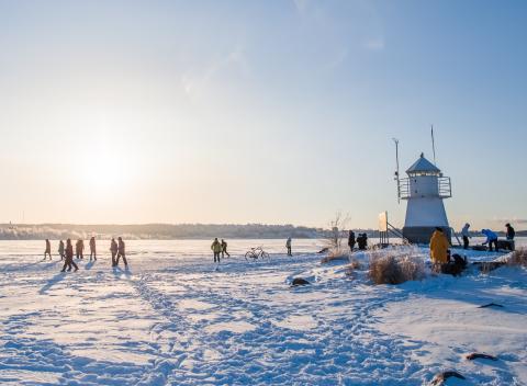 People in a sunny winter landscape on the ice of Lake Näsijärvi near the Siilinkari lighthouse.