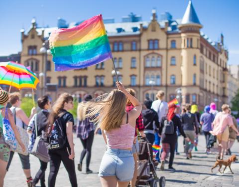 People with rainbow flags walking in Tampere.