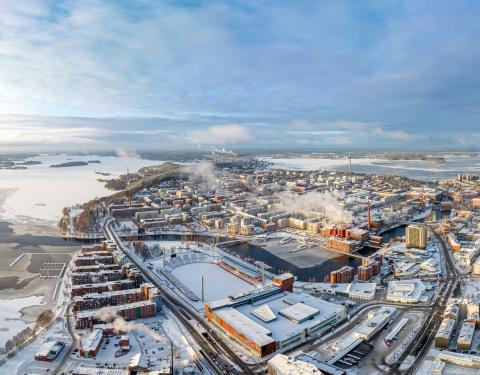 Dronella otettu maisemakuva, jossa etualalla luminen Nokia Arena ja Ratina, keskellä Tammerkoskea ympäröivät tiilitalot ja taustalla Näsijärvi.