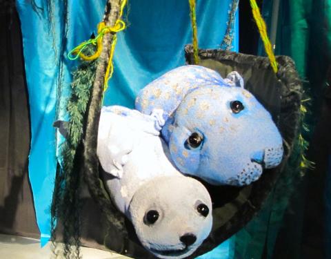 Kaksi nukketeatterinukkehyljettä makaa keinussa vierekkäin.