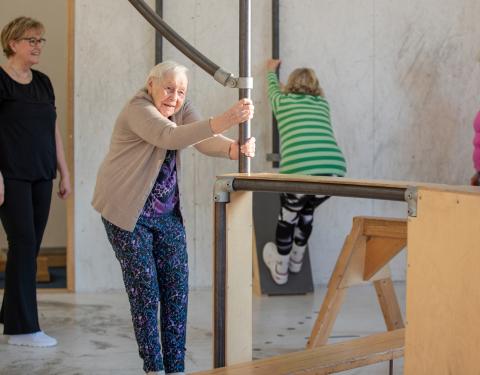 Neljä seniori-ikäistä naista liikuntasalissa.