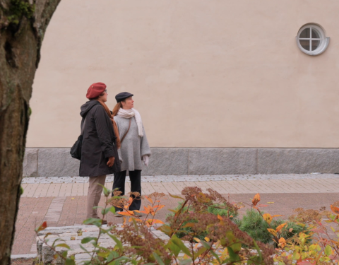 Kaksi henkilöä seisoo katsomassa Wivi Lönn -koulua.