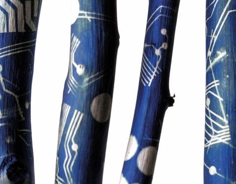 Maalattuja oksia, sinisellä pohjalla valkoisia kuvioita.