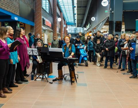 The choir performs in the lobby of the shopping center.
