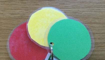 Three different coloured round pieces of cardboard: red, yellow, green.