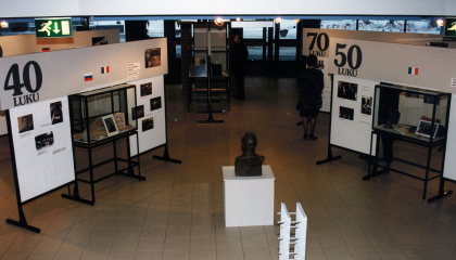 Historianäyttelyn seinäkkeitä rakennuksen aulassa. Keskellä veistos.