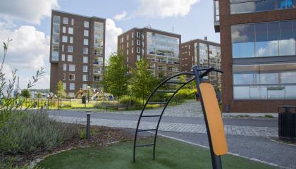 Ranta-Tampellan kuntoiluvälineitä, taustalla leikkipaikka ja kerrostaloja.