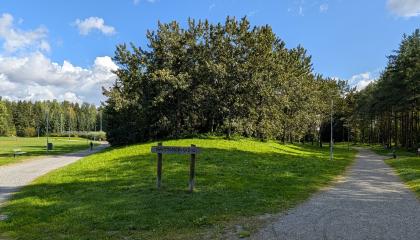 Näyttämönpuiston puita ja nimikyltti.