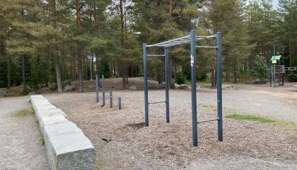 Matala kiviaita sekä roikkumiseen ja kuntoiluun sopivia telineitä.