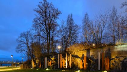 Kallepäätalon muistomerkki Maaltamuutto Alexandra Siltasen puistossa pimeän aikaan. 