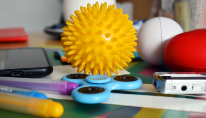 Oppimispulmissa käytettäviä välineitä: spinneri, kumipalloja, tusseja.