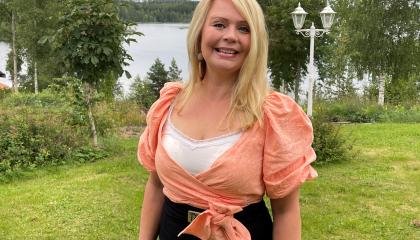 Yksi henkilö seisoo pihalla. Taustalla järvimaisema.