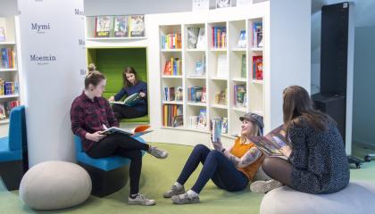 Neljä nuorta lukee ja juttelee lukukirjastossa Muumimuseossa.