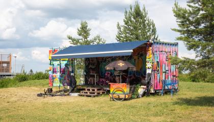 Graffitelilla kotisteltu työmaakontti kesäisessä skeittipuistossa.