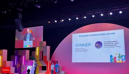 Palkintojenjakotilaisuus, jossa mies kävelee lavalle. 