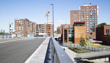 Ranta-Tampellassa kerrostalot rakenteilla. Etualalla silta aurinkoisena päivänä.