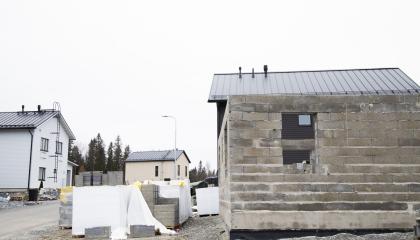 Etualalla rakenteilla oleva talo, taaempana kaksi valmista omakotitaloa.