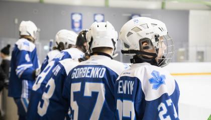 Nuoret jääkiekkoilijat katsovat jäälle.