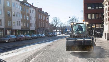Harjaustraktori puhdistaa jalkakäytävää.