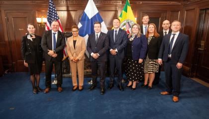 Delegaation väkeä seisoo rivissä kameralle hymyillen. 